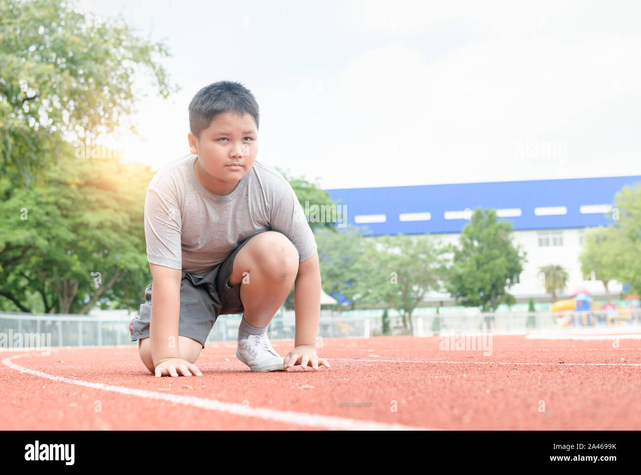 Mettre en place et en confiance dans la position de départ prêt pour courir. athlète pour enfants sur le point de commencer un sprint à propos concept d'exercice. Banque D'Images