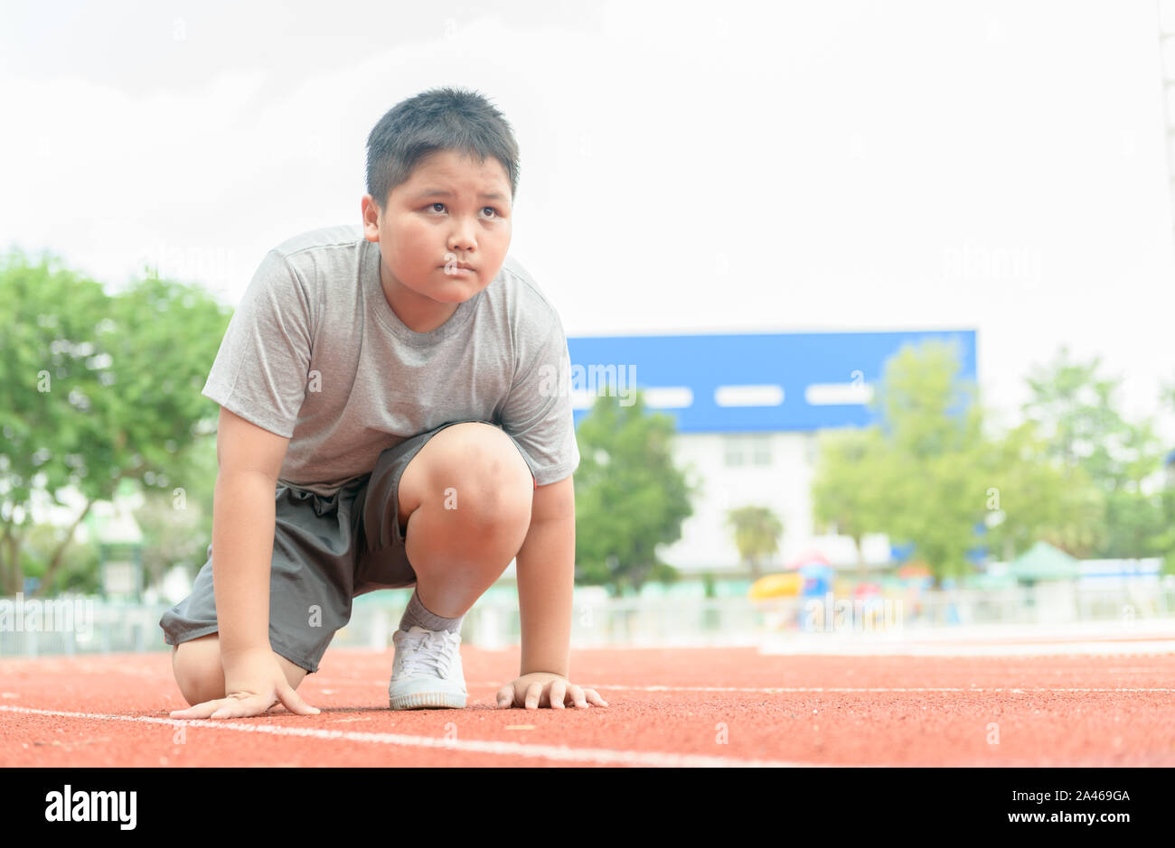 Mettre en place et en confiance dans la position de départ prêt pour courir. athlète pour enfants sur le point de commencer un sprint à propos concept d'exercice. Banque D'Images