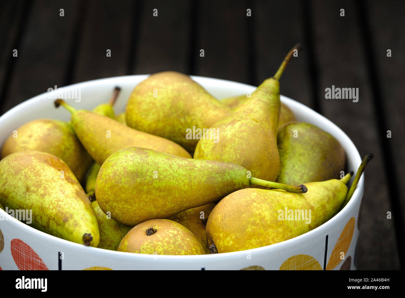 Poires Conférence, Pyrus communis, dans un bol sur une table. Ces poires dessert populaire sont délicieusement mûr et prêt à être mangé Banque D'Images