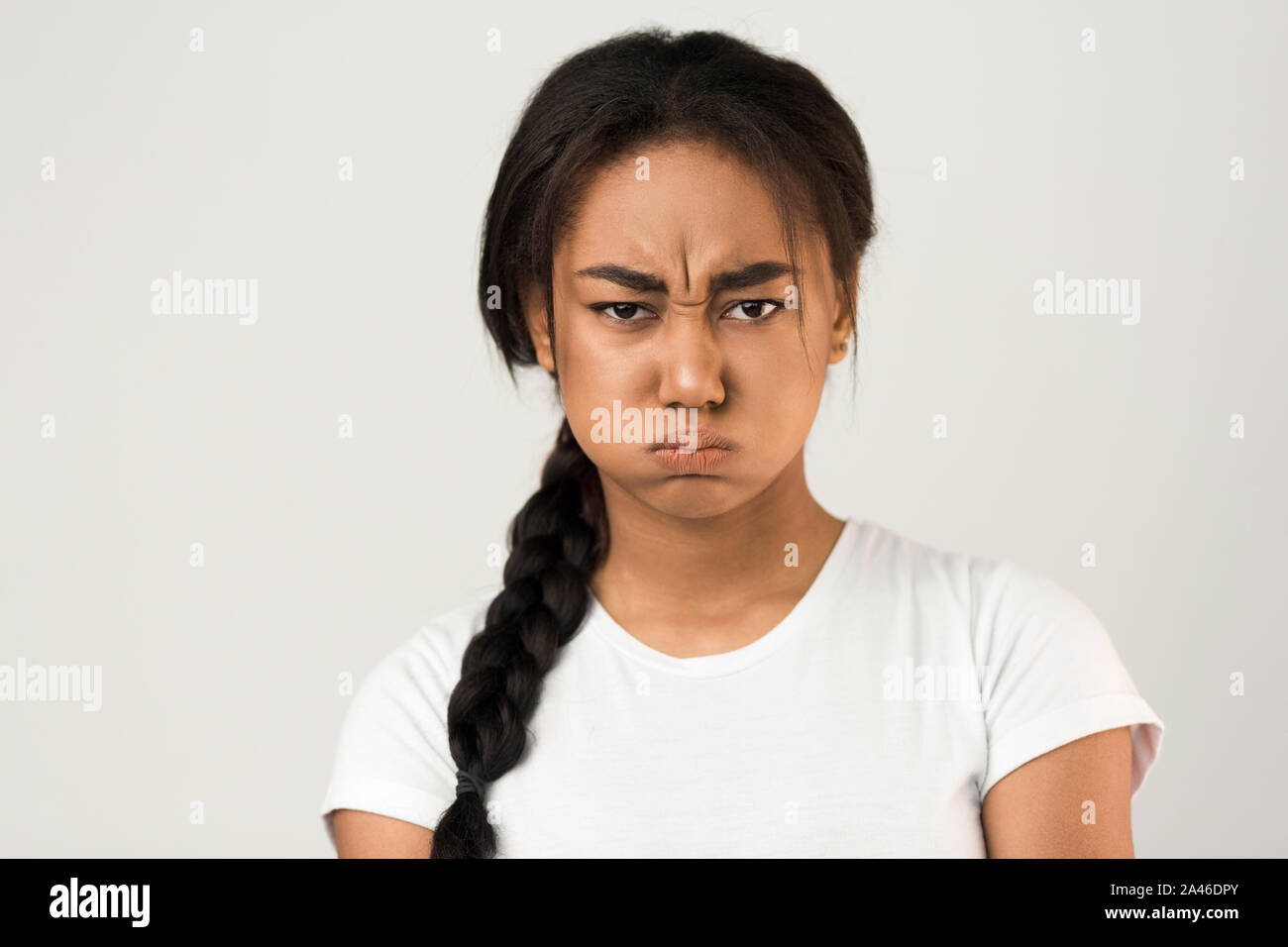 Angry afro girl blowing ses joues, fond gris Banque D'Images