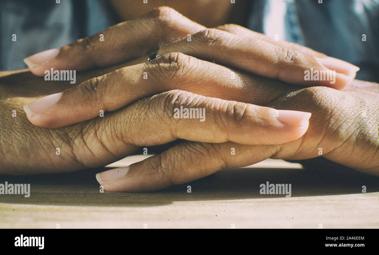 Femme noire en entrelaçant les doigts. Les mains jointes. Effet analogique. Banque D'Images