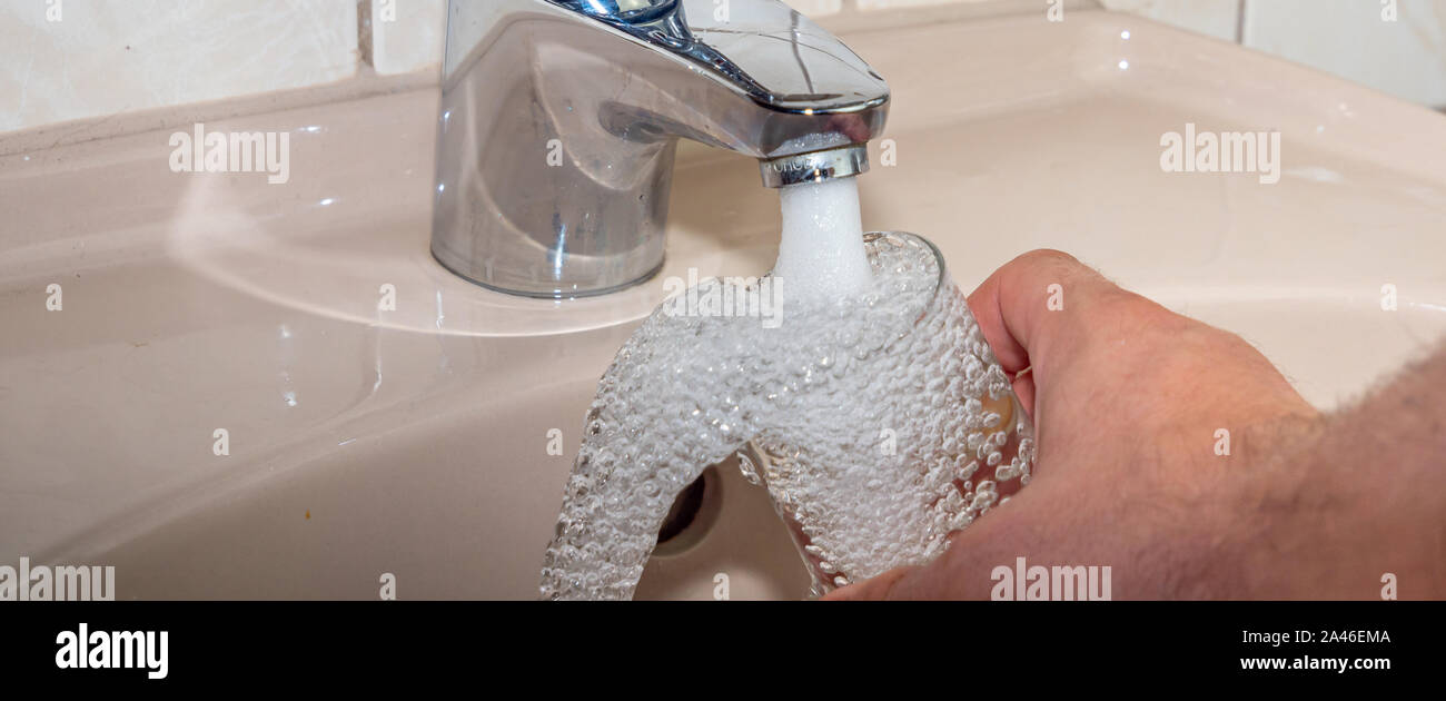 L'eau potable Panorama femme remplit le verre avec de l'eau Banque D'Images