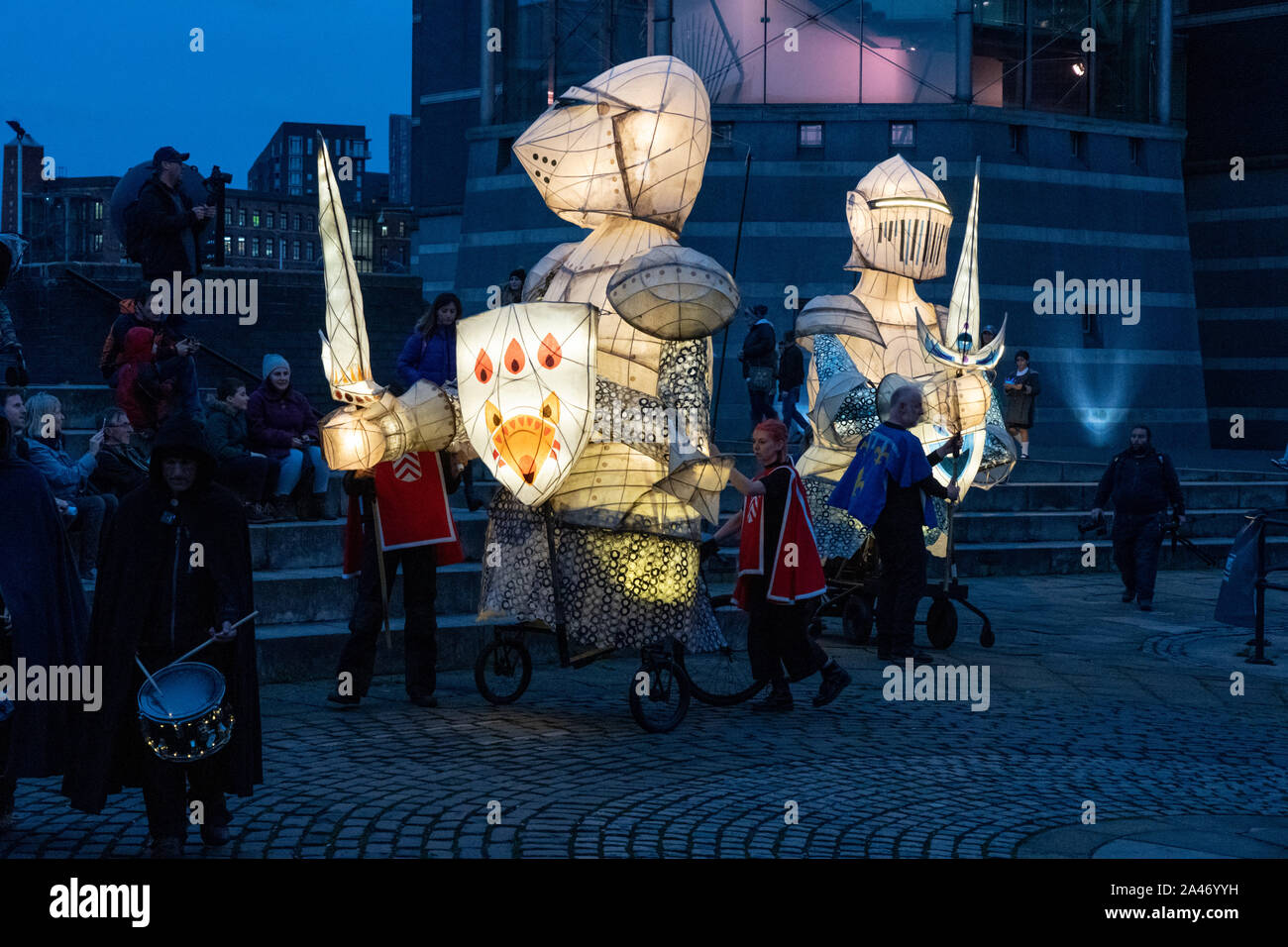 À Dusk, des chevaliers lumineux géants se sont produit lors d'un événement public en direct. À côté du musée Royal Armouries, Leeds, West Yorkshire, Angleterre, Royaume-Uni. Banque D'Images