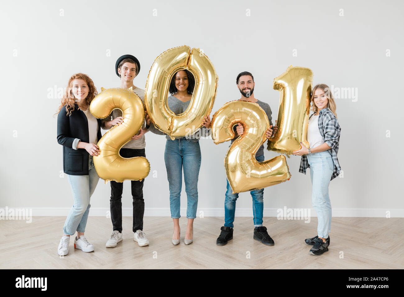 Groupe multiculturel de jeunes amis occasionnels par nombre de nouvelle année Banque D'Images