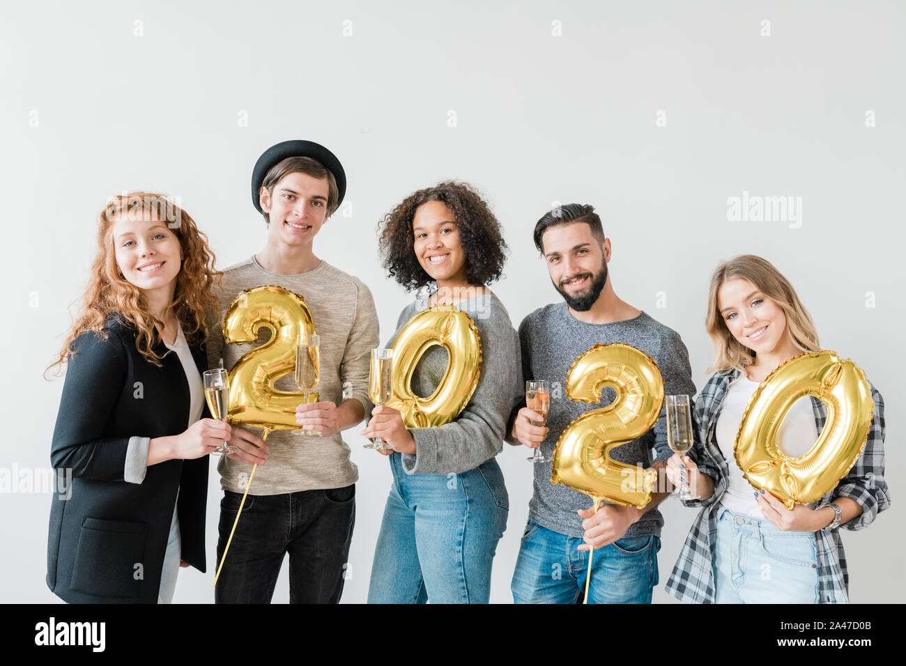 Les jeunes gens sympathiques joyeux holding nombre de nouvelle année et flûtes avec chamagne Banque D'Images