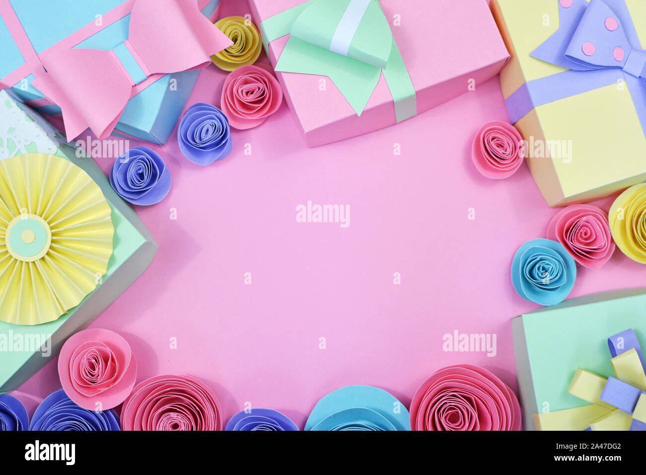 Mise à plat de fond avec du papier de couleur pastel avec des boîtes de cadeaux et rubans roses papier copie espace encadrement en milieu de fond rose Banque D'Images