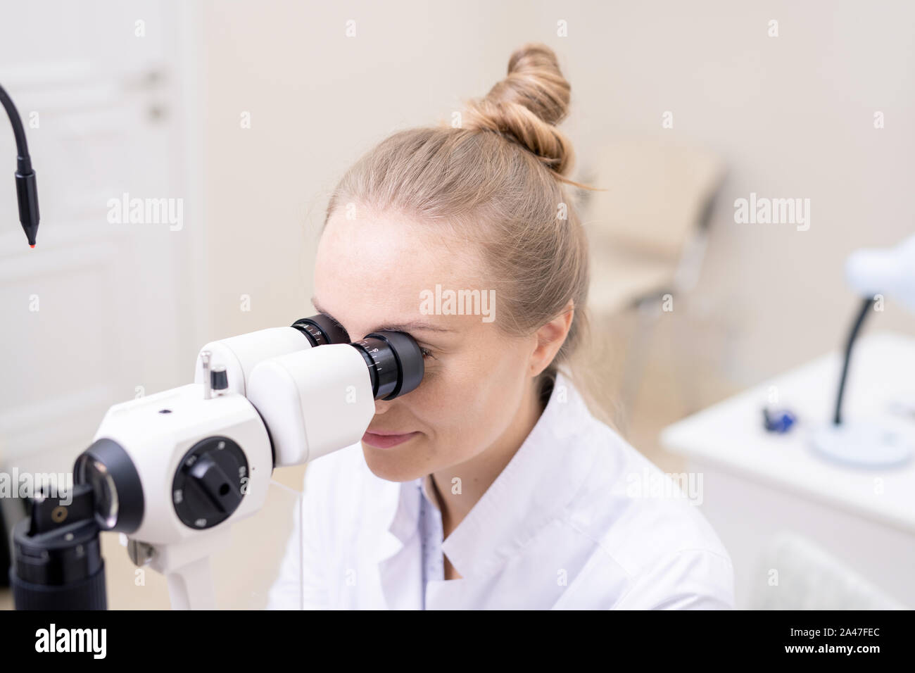 Très jolie yeux regardant à travers l'équipement d'optométrie Banque D'Images
