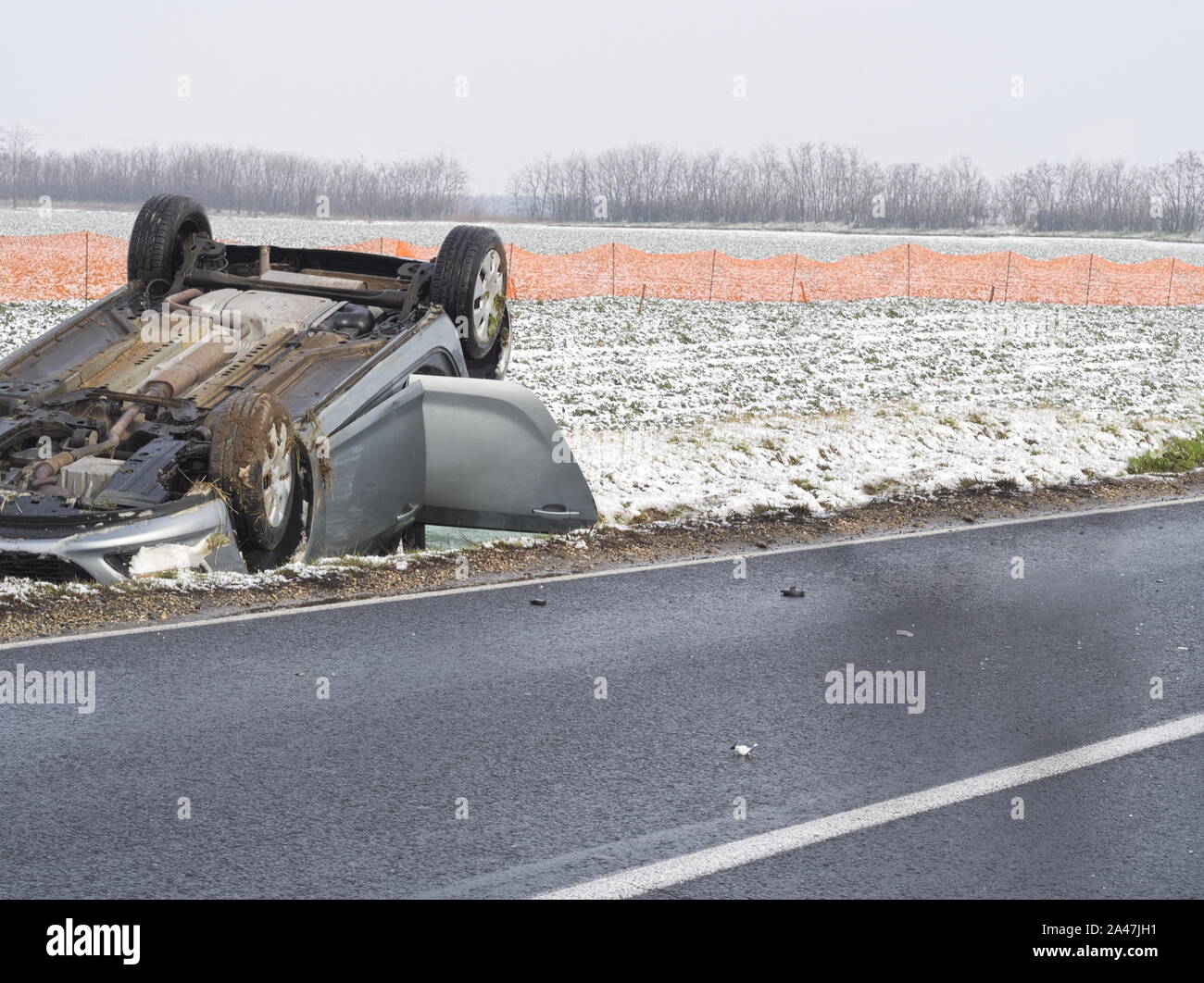 Annulée voiture à côté de la route mouillée par une journée d'hiver Banque D'Images