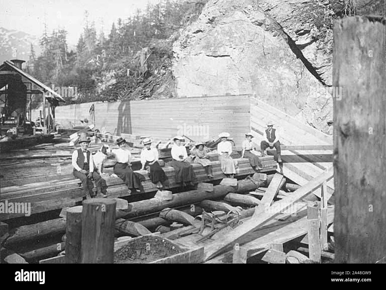 Cinq femmes non identifiées d'un petit enfant et deux hommes assis sur le canal de Porcupine Gold Mining Company (Porcupine d'al +CA 2326). Banque D'Images Cinq femmes non identifiées d'un petit enfant et deux hommes assis sur le canal de Porcupine Gold Mining Company (Porcupine d'al +CA 2326). Banque D'Images