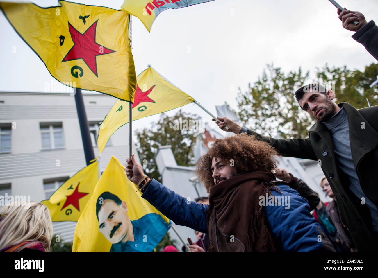 Varsovie, Pologne. Oct 11, 2019. Peuple kurde brandissant des drapeaux pendant la manifestation.Des centaines de personnes se sont réunies à l'ambassade de Turquie à Varsovie pour protester contre l'invasion turque du nord de la Syrie et de faire preuve de solidarité avec le peuple kurde. Les manifestants kurdes autochtones qui sont venus avec les drapeaux du Kurdistan, GPJ (unités de protection du peuple), le PKK (Parti des Travailleurs du Kurdistan) et avec l'image d'Abdullah Öcalan, chef du PKK. Credit : SOPA/Alamy Images Limited Live News Banque D'Images