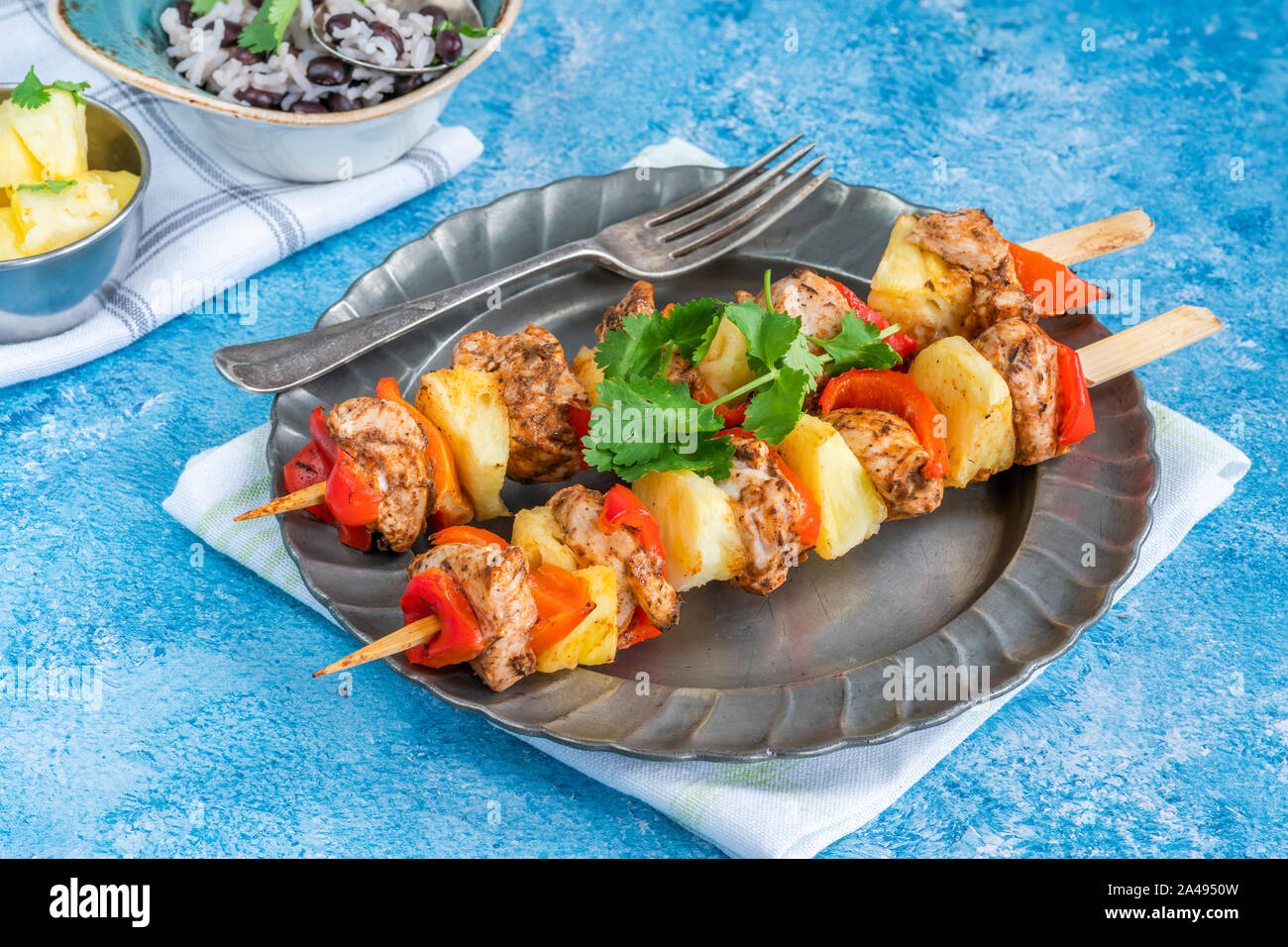 De poulet jerk et ananas brochettes avec du riz aux haricots noirs Banque D'Images