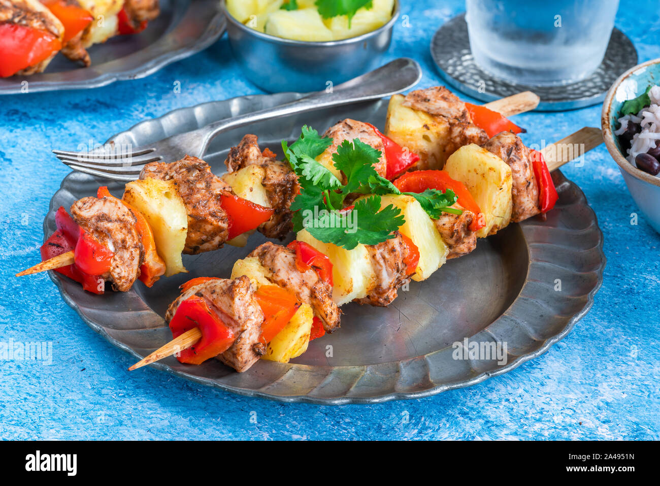 De poulet jerk et ananas brochettes avec du riz aux haricots noirs Banque D'Images