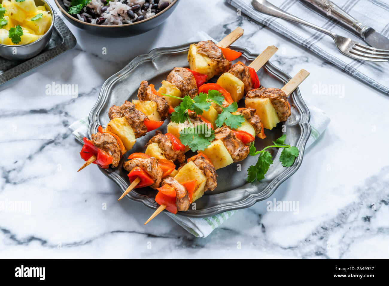 De poulet jerk et ananas brochettes avec du riz aux haricots noirs Banque D'Images