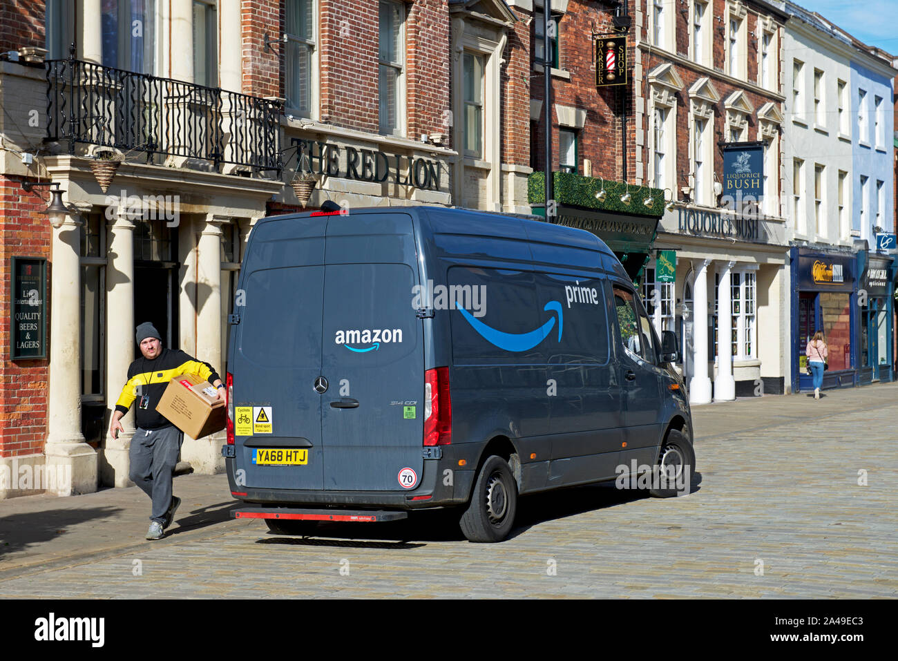 Man et colis Amazon premier camion de livraison, Pontefract, West Yorkshire, England UK Banque D'Images