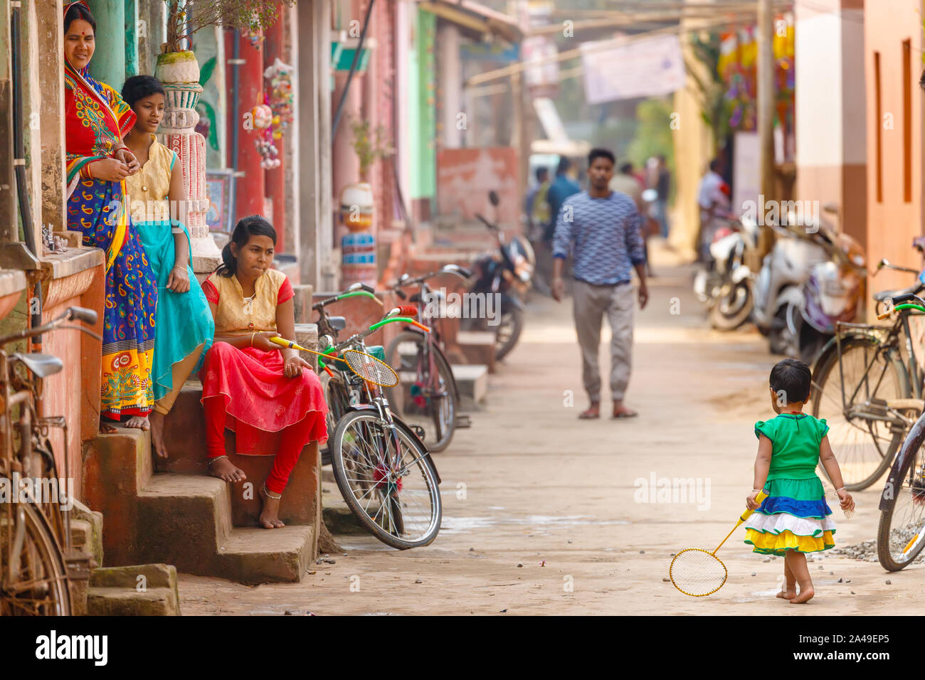 RAGHURAJPUR, INDE, LE 14 JANVIER 2019 : chers indiens sont assis sur les marches à regarder une petite fille jouer au badminton dans Raghurajpur, l'artisanat famo Banque D'Images