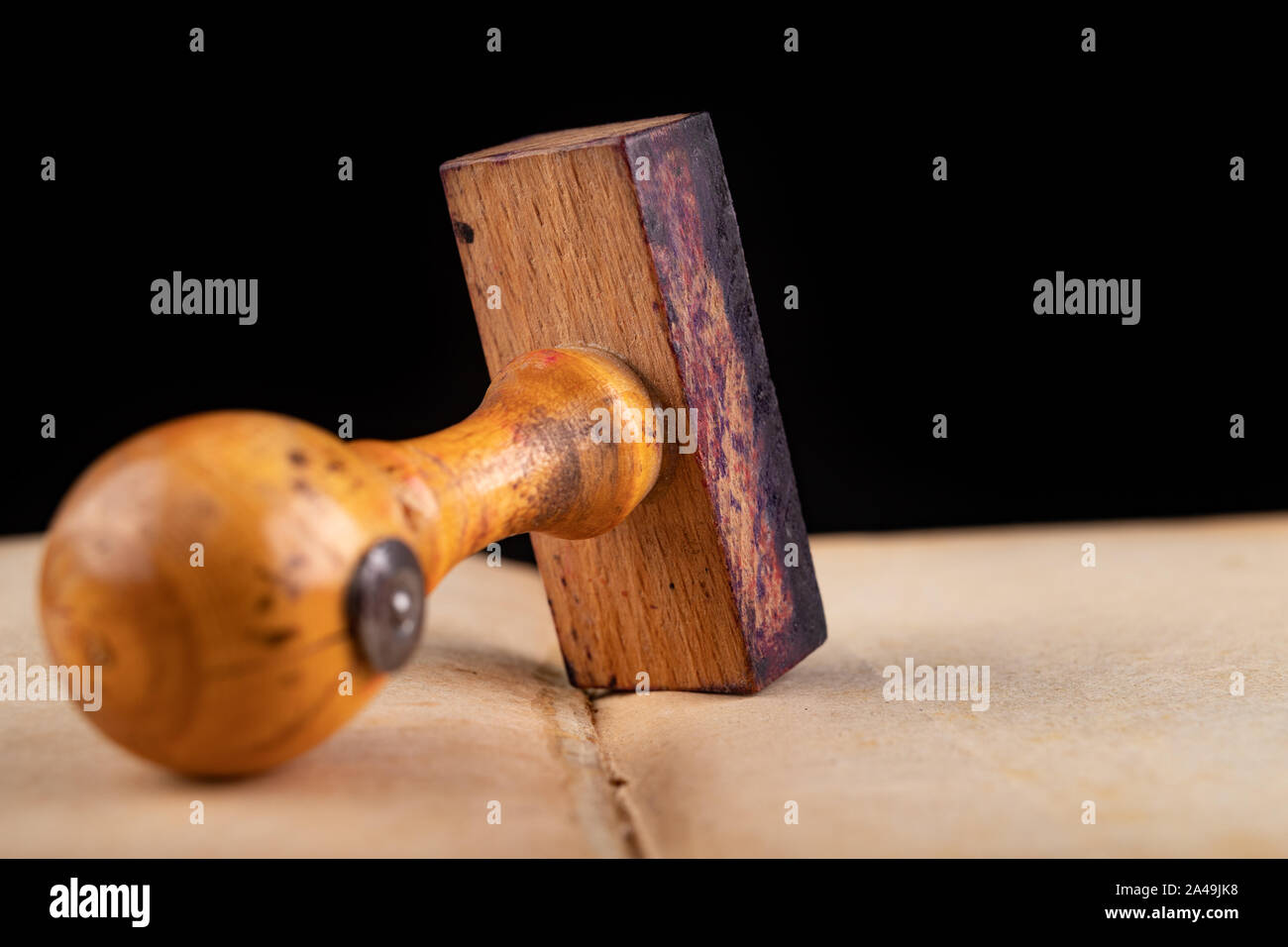 En bois ancien tampon de caoutchouc sur le livre. Accessoires de bureau  utilisé dans le bureau. Fond sombre Photo Stock - Alamy
