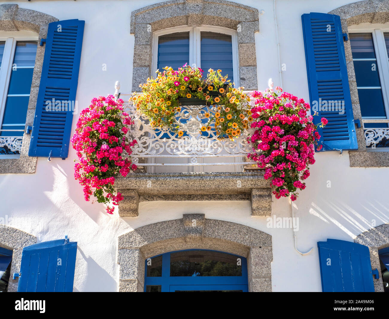 PONT AVEN Maison de Maître 'MANSION' avec d'abondantes fleurs colorées balcon et fenêtres à volets bleu traditionnel Pont Aven Bretagne France Banque D'Images