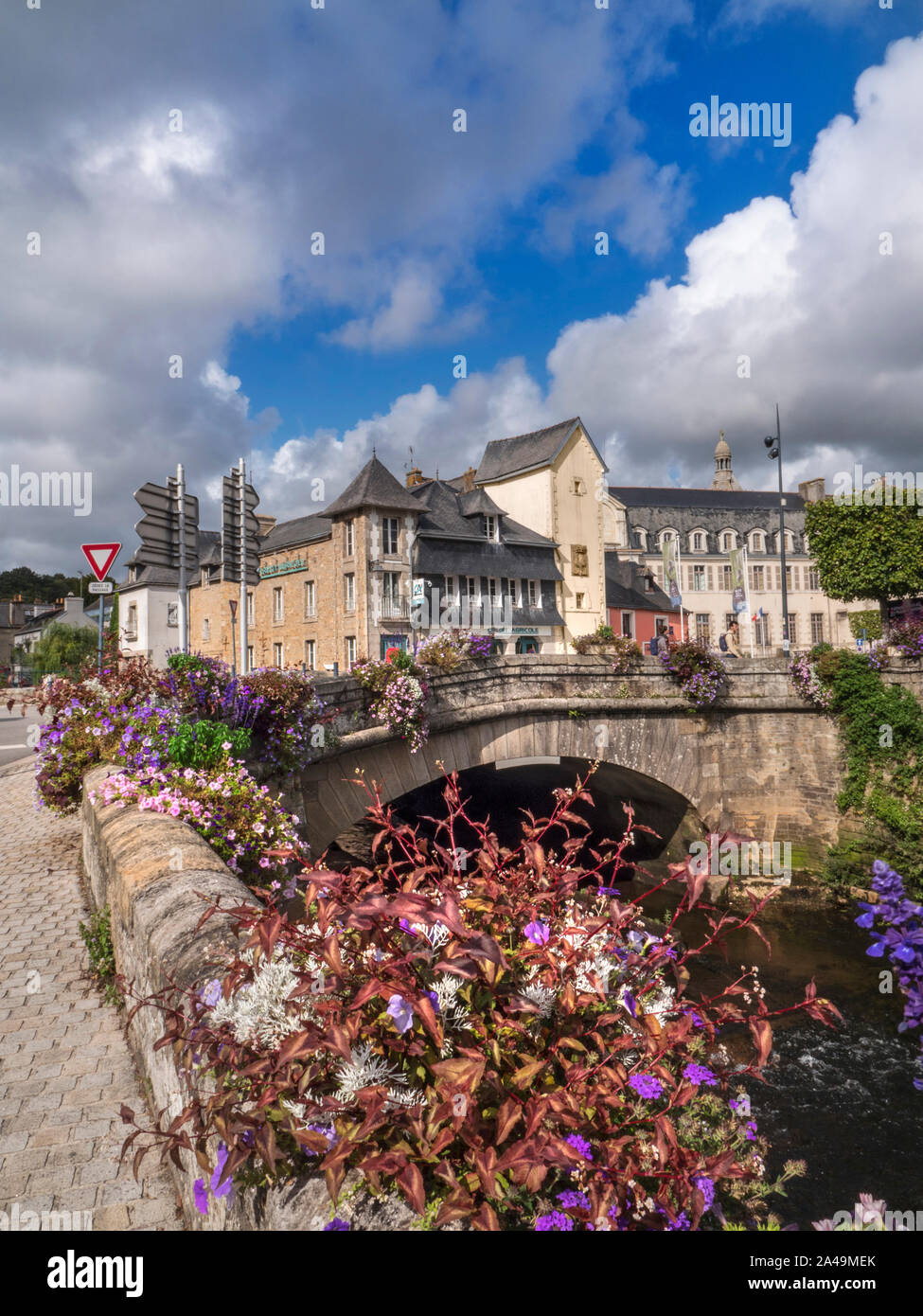 Quimperlé Bretagne Finistère France sur la rivière Laita avec pont et fleurs en premier plan et dramatique ciel d'automne au nord ouest de la France Banque D'Images