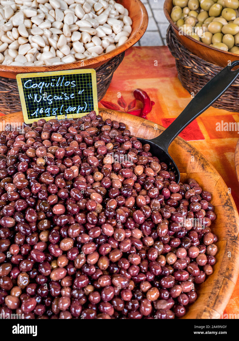 COQUILLOS OLIVES NIÇOISE Breton stand vente d'une variété d'olives à l'nisçoise les olives en premier plan dans le bol en bois au marché alimentaire à Moelan sur Mer Banque D'Images