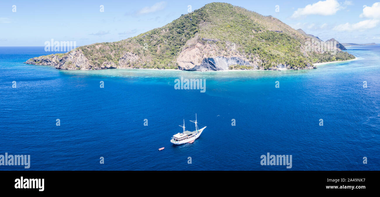 Une île tropicale dans la banda mer est entouré d'un magnifique récif de corail. Cette région de l'Indonésie est le foyer de biodiversité extraordinaire. Banque D'Images