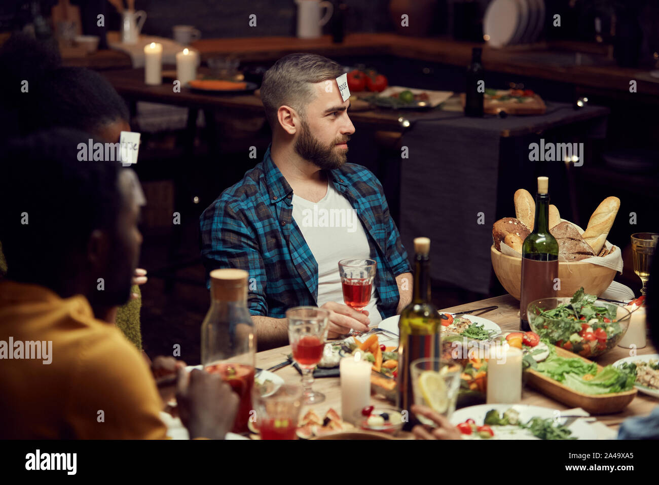 Portrait de jeune homme barbu jeu de devinettes à jouer avec des amis au  cours de partie de dîner, copy space Photo Stock - Alamy