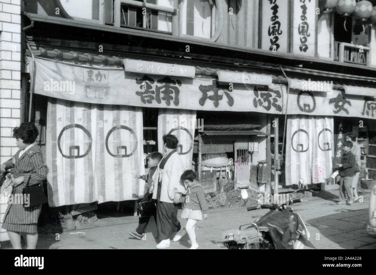 Les gens devant l'entrée de boutiques traditionnelles, Japon 1958 Banque D'Images