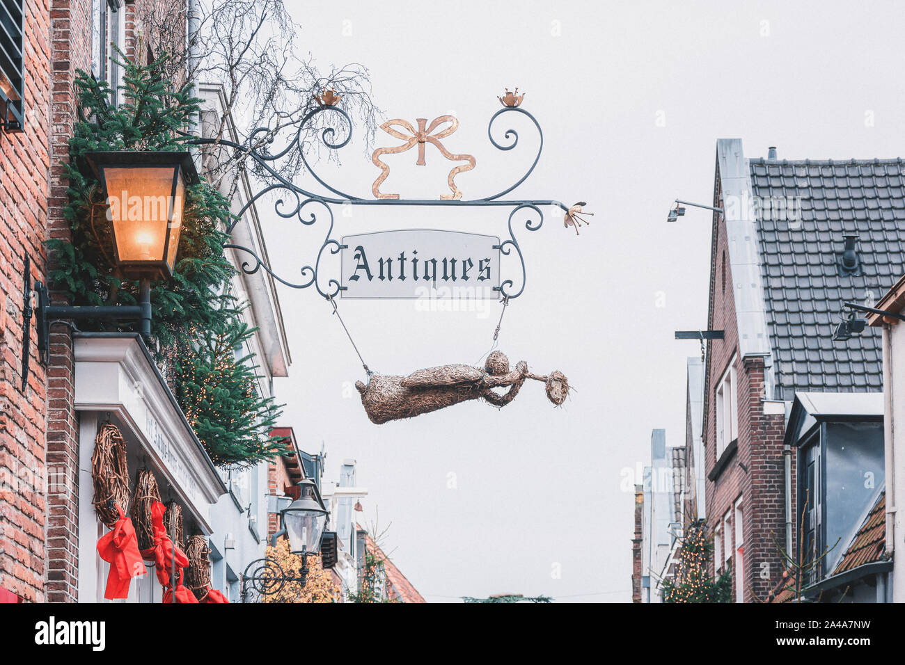 Deventer, Pays-Bas - 15 décembre 2018 : l'enseigne d'un antiquaire décorée avec un ange de paille durant le festival Dickens Banque D'Images