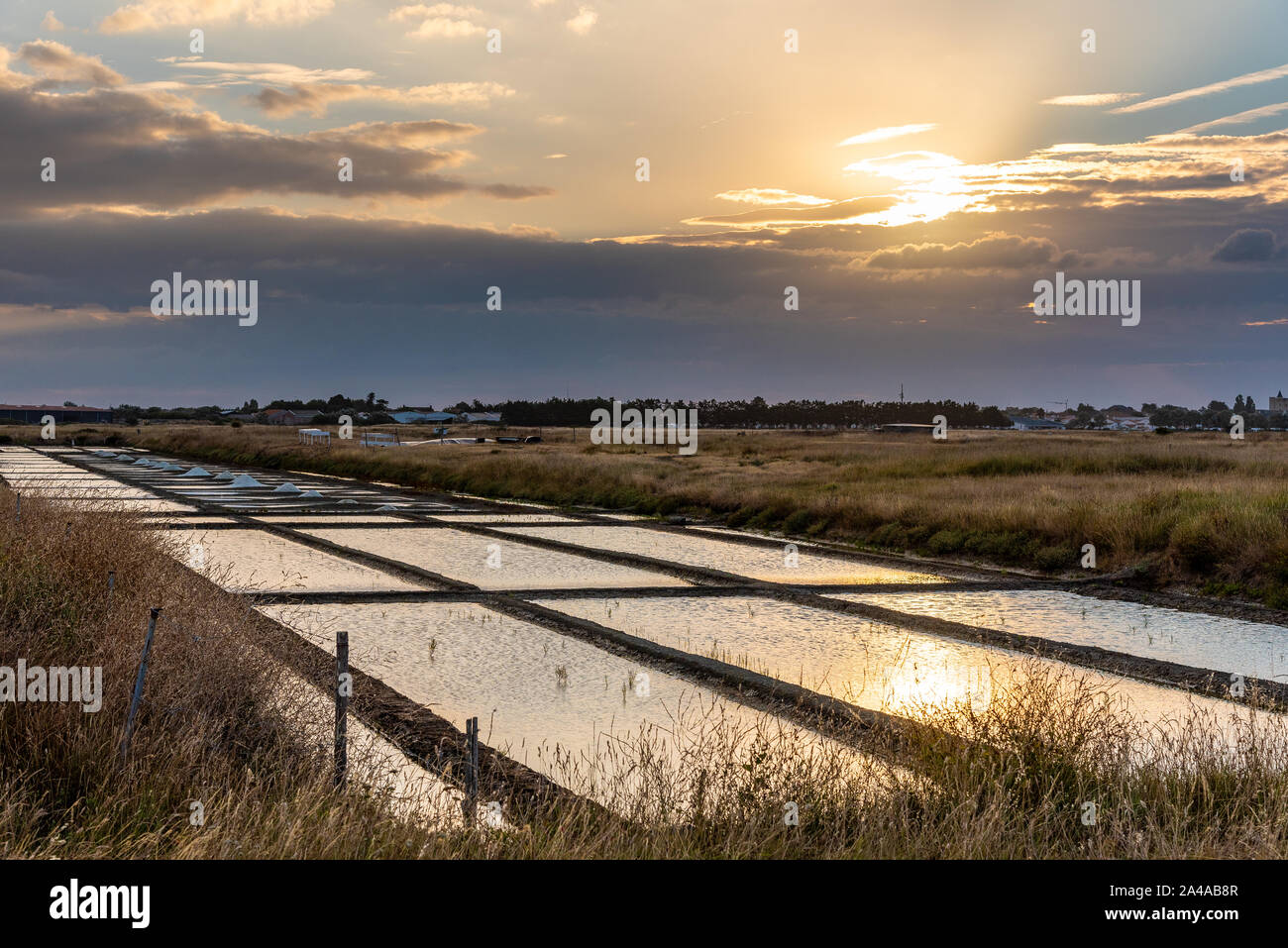 Les marais salants de l'île de Noirmoutier en France. Le soleil se lève sur des étangs, bassins et des tas de sel Banque D'Images