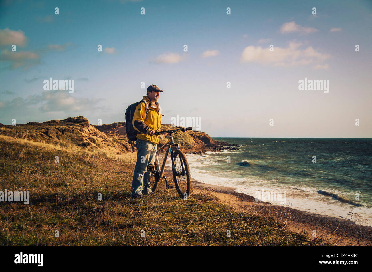 Randonnée à vélo en Irlande. Cycliste avec loisirs vtt et sac à dos sur le bord des dunes de sable face à la mer. Banque D'Images