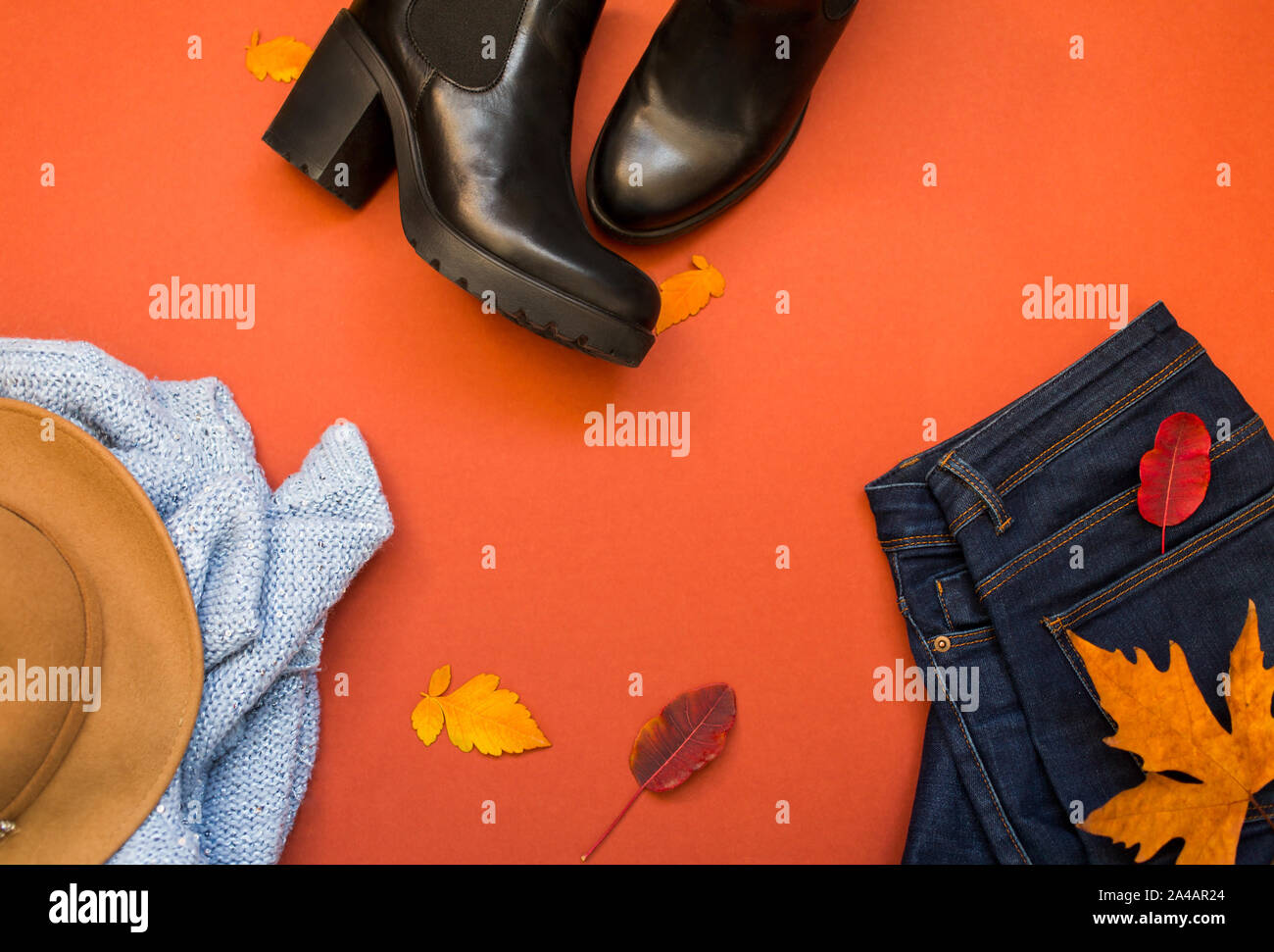 Vêtements Femme - costume sweter bleu et jeans sur un fond terracote, vue du dessus. Hiver, automne habillement femme Banque D'Images