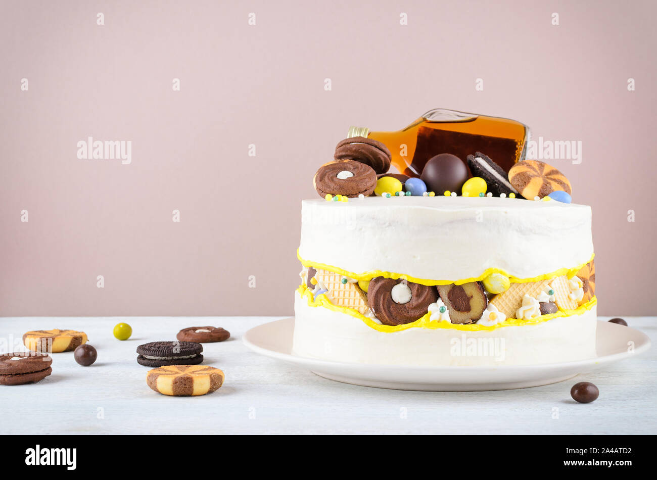 Drôle de gâteau avec une bouteille d'alcool, des bonbons et biscuits Banque D'Images