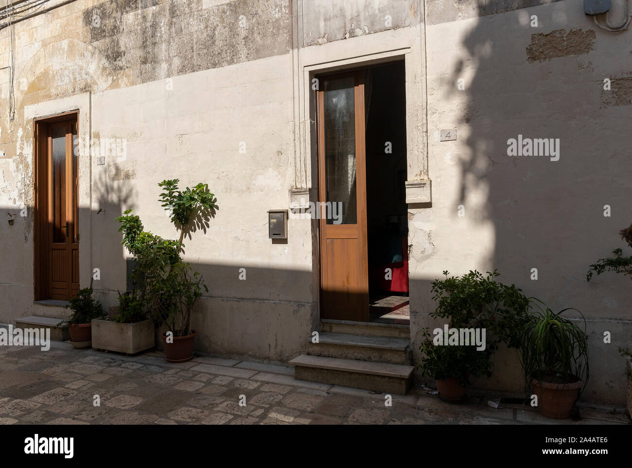 Martano, Messapian ville. Salento, Pouilles Italie. Rue principale de pierre. Vue sur des portes d'accès aux maisons basses. Salle de séjour et une chambre donnant sur le s Banque D'Images