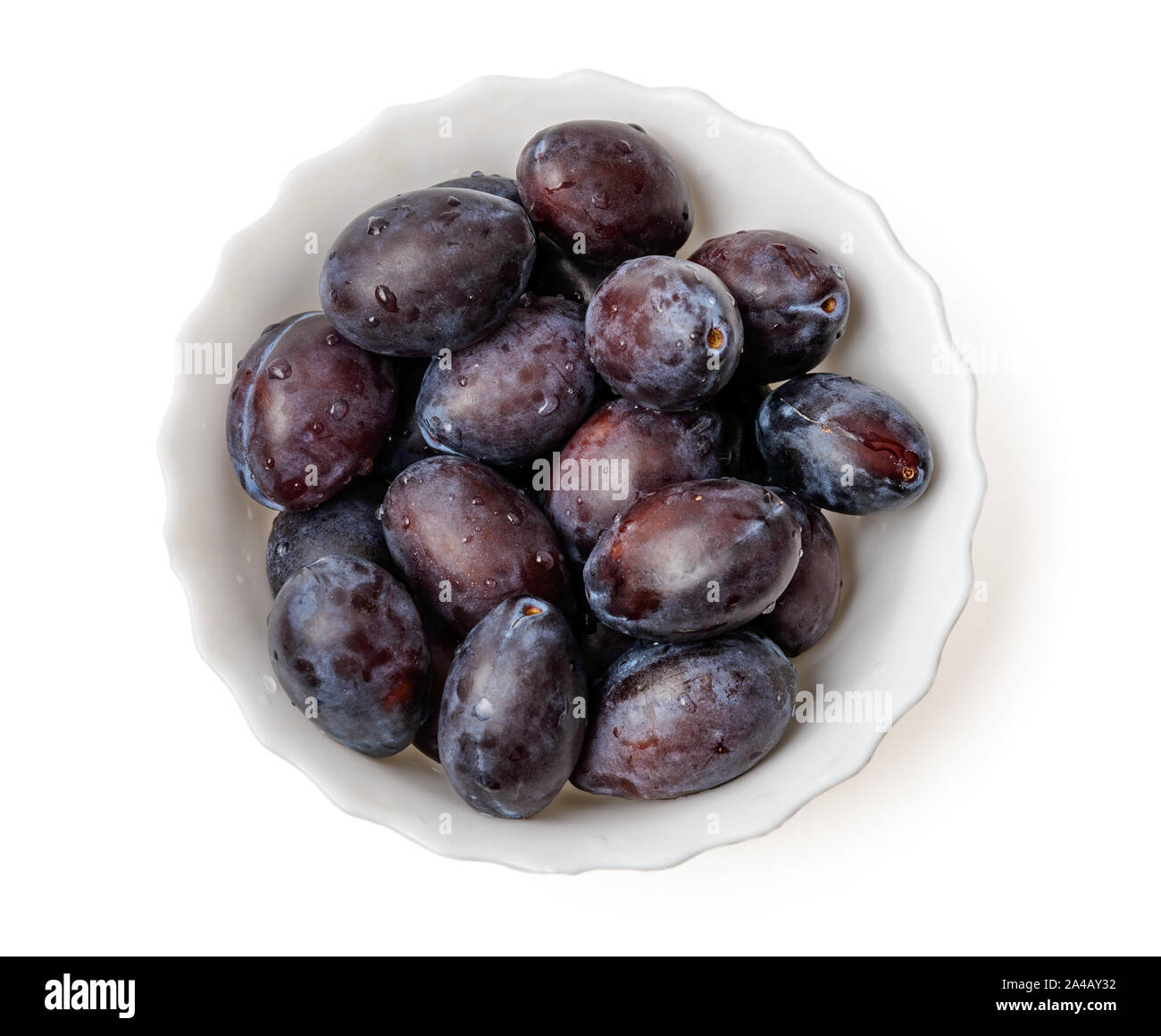 Les prunes dans un bol damson violet top view isolated on white background with clipping path Banque D'Images