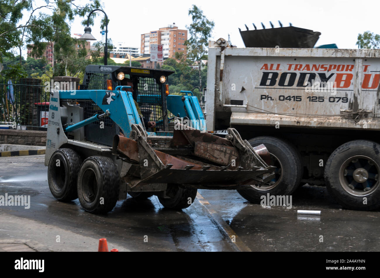Le nettoyage après les récentes inondations à Brisbane, Queensland, Australie. Un chariot élévateur transportant un équipement endommagé par les inondations vers un chariot d'élimination en attente Banque D'Images
