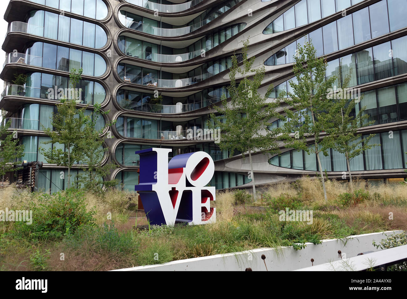 08 septembre 2019, nous, New York : un bâtiment résidentiel par star architecte Zaha Hadid, décédé en 2016, se trouve juste à côté du parc High Line. En face d'elle se dresse la célèbre 'Amour' sculpture de Robert Indiana. Le parc High Line est un conservés mais ne sont plus utilisés en viaduc ligne dans l'ouest de Manhattan. La première phase de construction a ouvert ses portes en 2009. Il est l'un des nouveaux parcs et les plus insolites à New York et déjà un spectacle à voir. Il est près de trois kilomètres de long et seulement environ 20 mètres de large. High Line est situé à 10 mètres au-dessus de la route entre les 10e et 11e avenues et va Banque D'Images