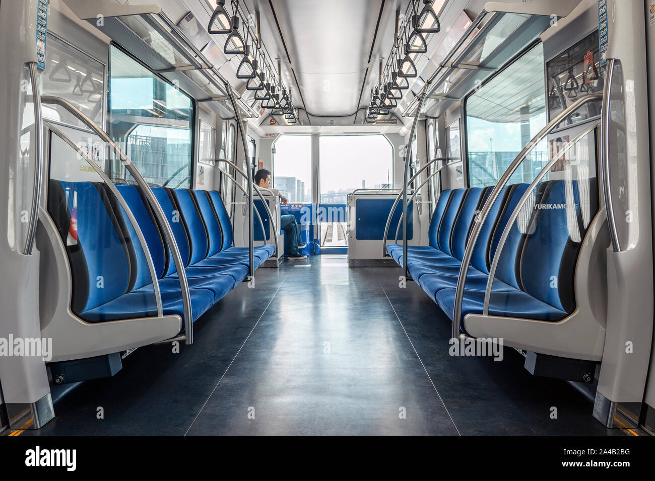 TOKYO, JAPON - 6 octobre 2018. Un des hommes est assis dans la voiture de métro vide. White et nettoyer l'intérieur de l'Entraîneur Monorail avec sièges bleus. Banque D'Images