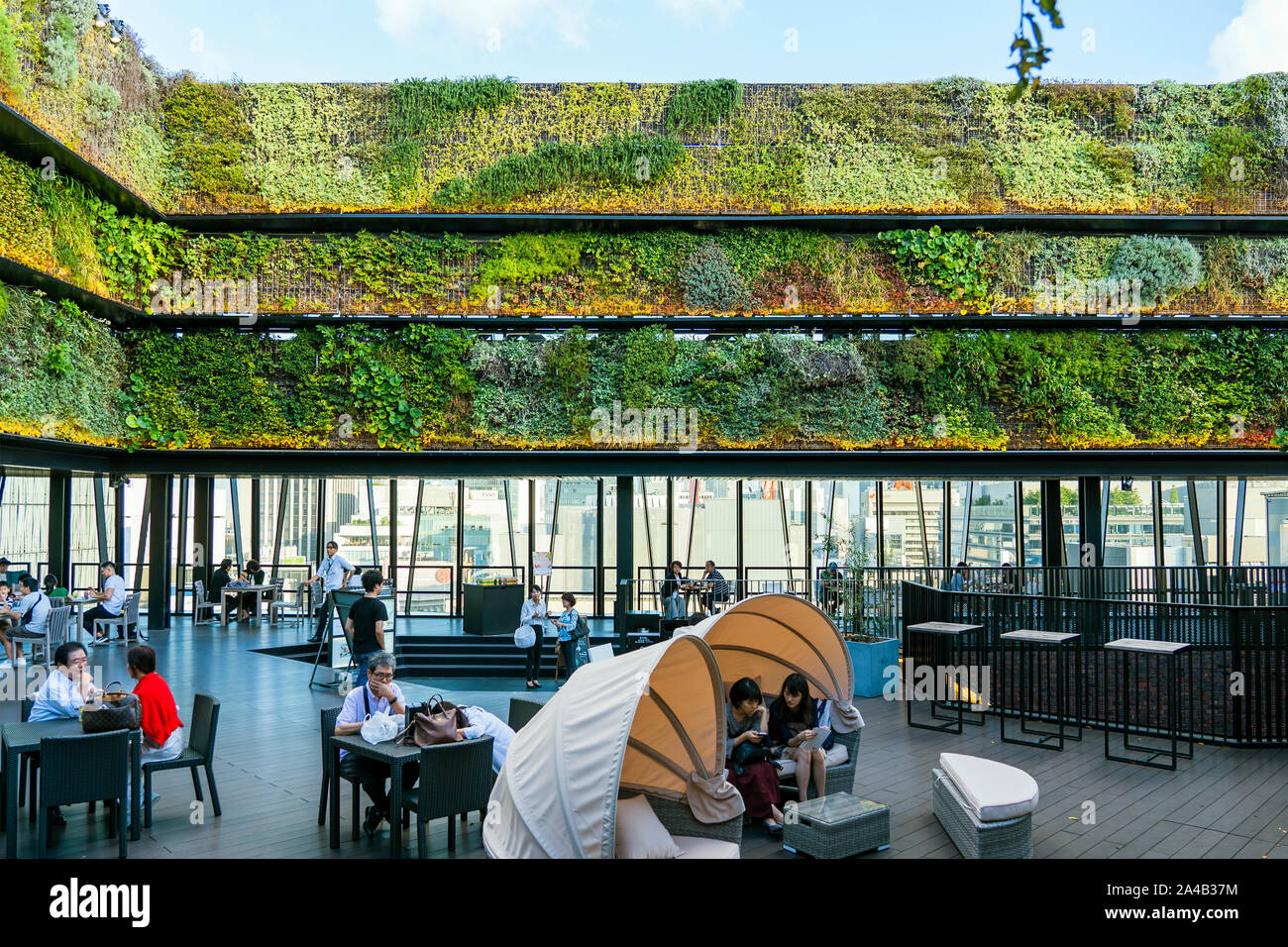 TOKYO, JAPON - 6 octobre 2018. Paroi verticale verte et une terrasse en plein air. Café et restaurant sur le toit est plein de gens. Traitement du parapet W Banque D'Images
