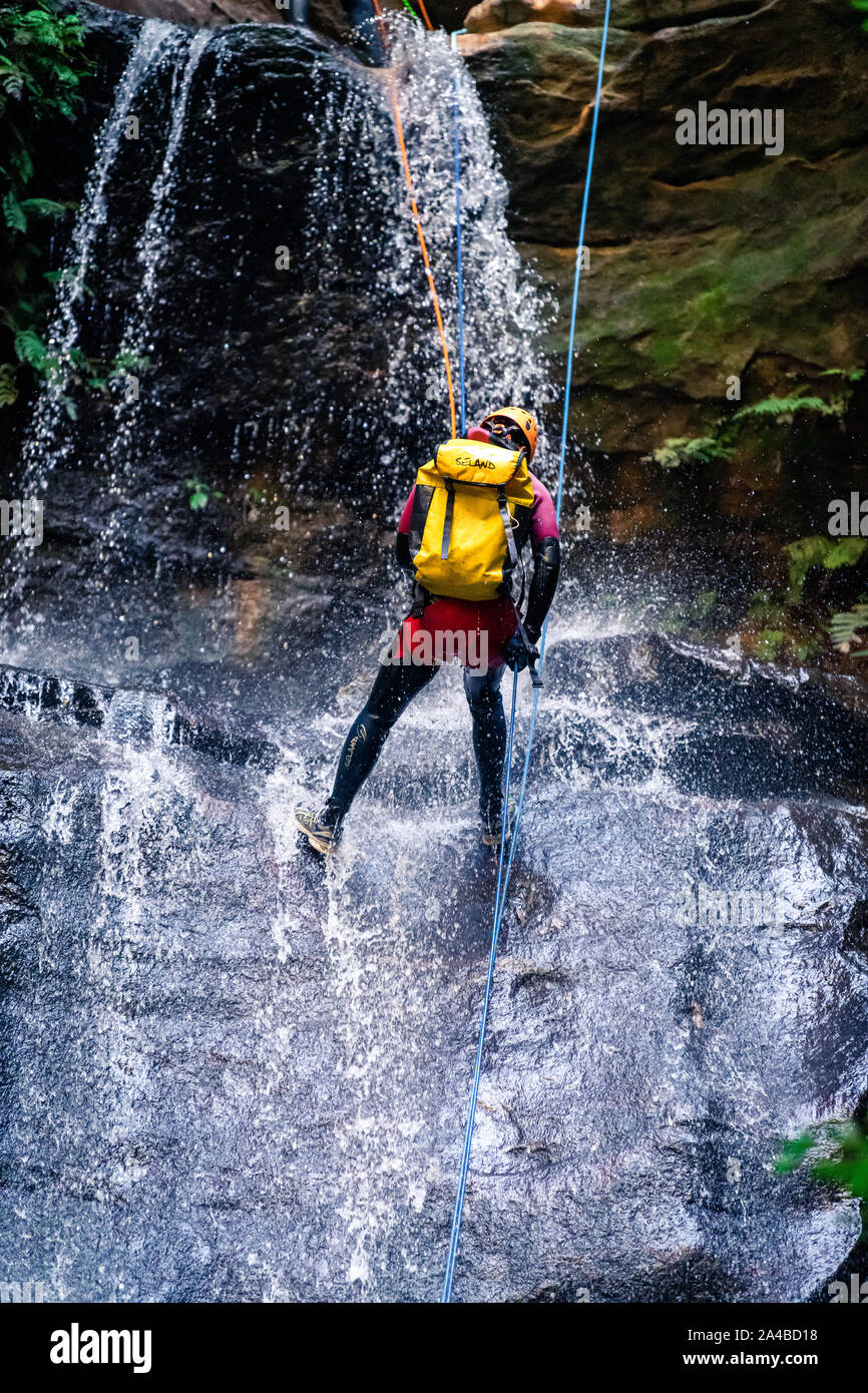 L'impératrice Falls, Blue Mountains, Australie - 7 Sept 2019 : l'homme descendre long drop cascade sur roches glissantes, le port de sac à dos, avec Banque D'Images