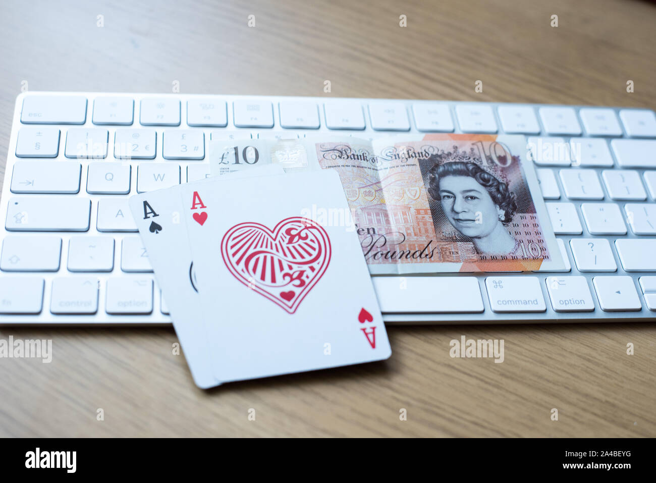 En ligne le jeu de poker et jouer avec le clavier sur un tableau avec double as et un dix livres britanniques en polymère Banque D'Images
