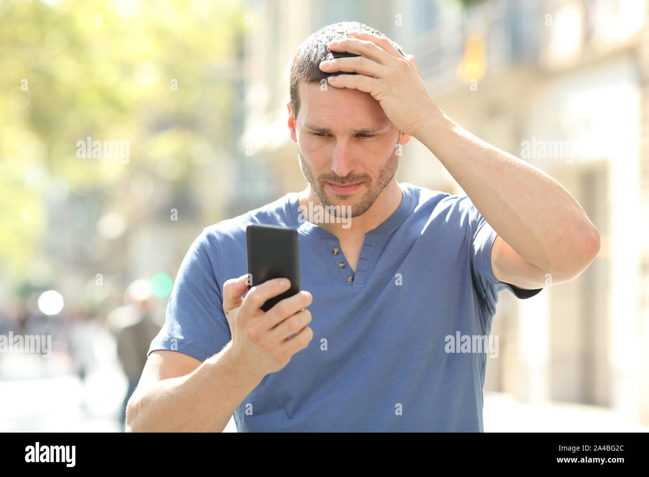 L'homme confus se plaindre après erreur checking mobile phone content dans la rue Banque D'Images