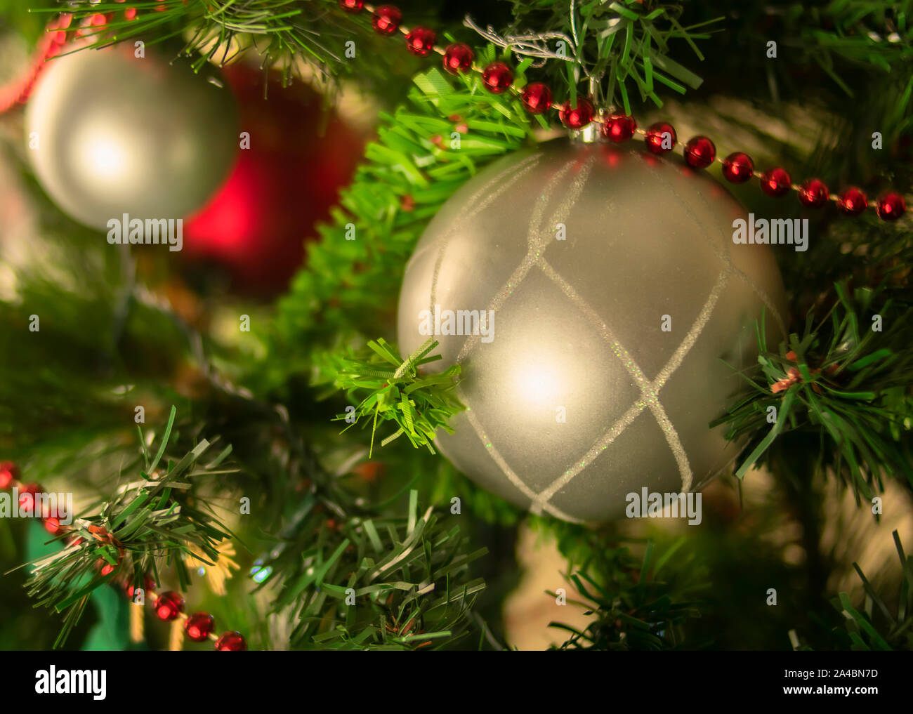 Bal de Noël d'argent à un arbre artificiel avec du rouge et sphérique, décorations avec des paillettes, vert, rouge et des tons d'argent Banque D'Images