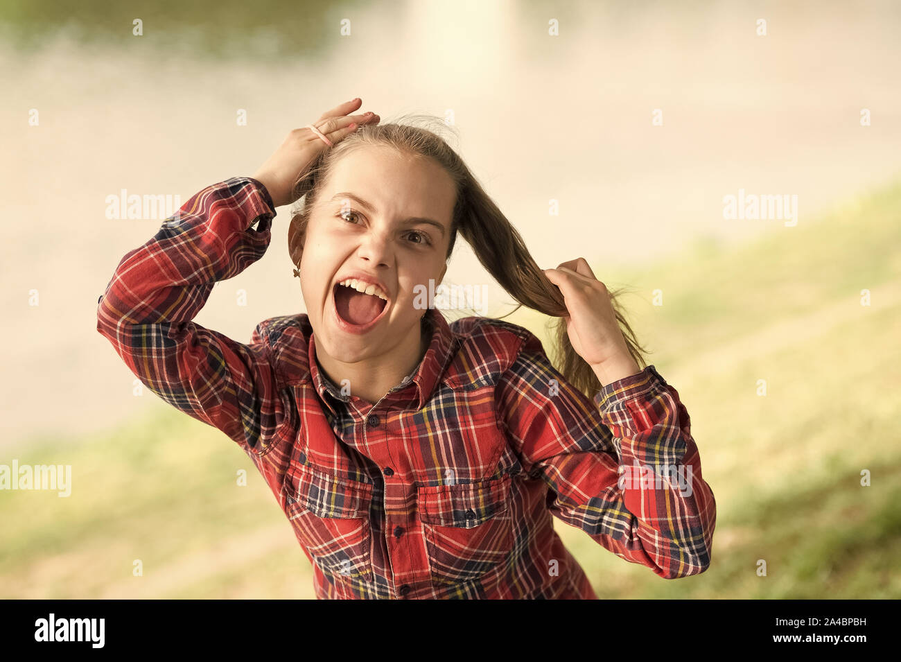 Traiter les cheveux longs sur jour de vent. Coiffures coupe-vent. Peu de fille cute child profitez à pied sur la nature de fond jour venteux. Coiffures à porter les jours de vent. Sentiment intime et confortable sur jour de vent. Banque D'Images