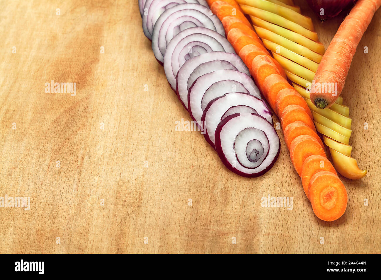 Couper les légumes crus carotte, poivron jaune, l'oignon sur la table en bois. Vue d'en haut Banque D'Images