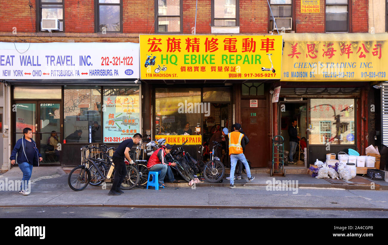 NY devantures Chinatown sur Madison St -- chinatown bus, e réparation de vélos, vente en gros de fruits de mer -- 118-120 Madison St. Banque D'Images
