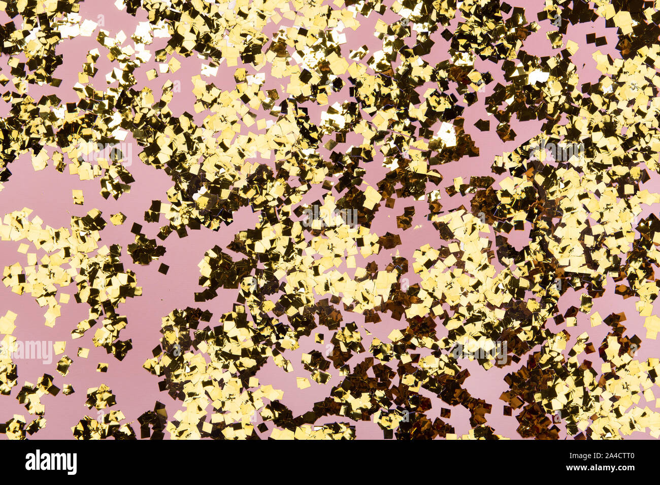 Glitter confetti doré sur fond rose. Toile pastel de vacances festives. Greeteng modèle de cartes. Banque D'Images