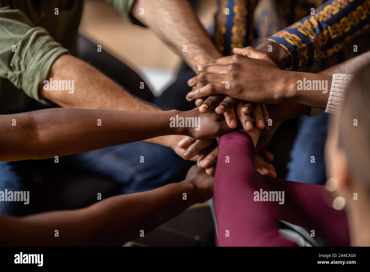 Portrait d'affaires diversifié fermer leur main sur le dessus de l'autre portant des vêtements décontractés et des motifs africains. Banque D'Images