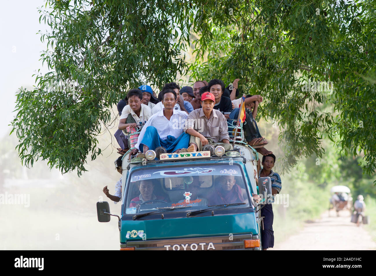 Les hommes birmans ride to work dans une vieille Toyota sur la périphérie de Mandalay, Myanmar. Banque D'Images