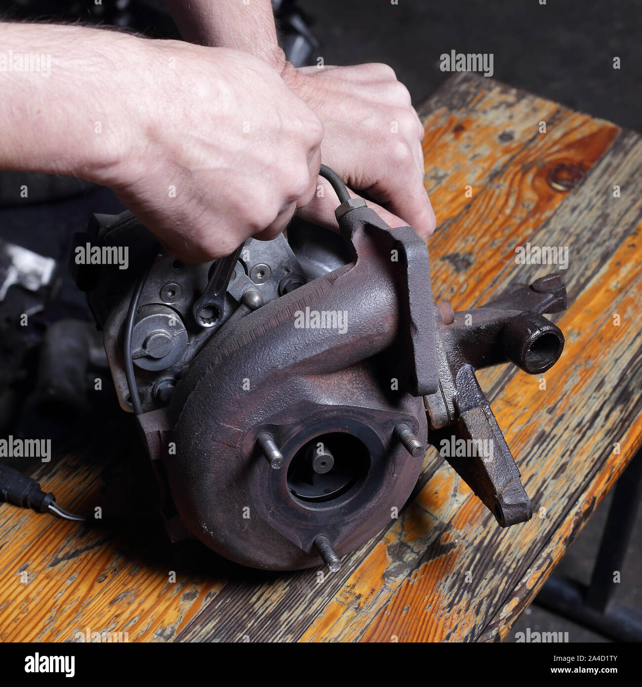 Car service - réparation du moteur avec une clé mains mécanicien, désactive l'écrou du compresseur centrifuge Banque D'Images