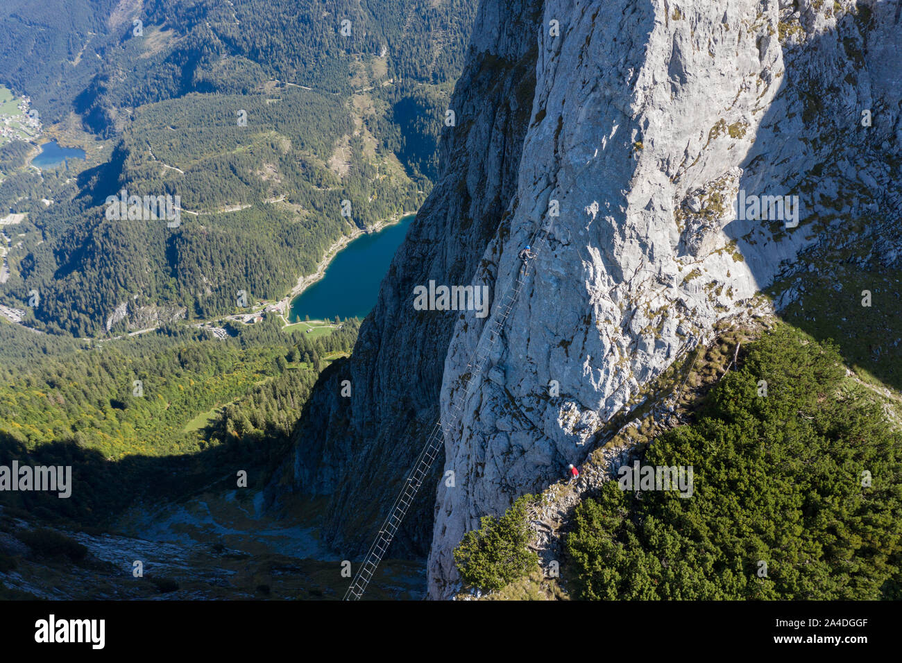 Homme qui regarde une femme grimpant une via ferrata, Gosau, Gmunden, Haute Autriche, Autriche Banque D'Images