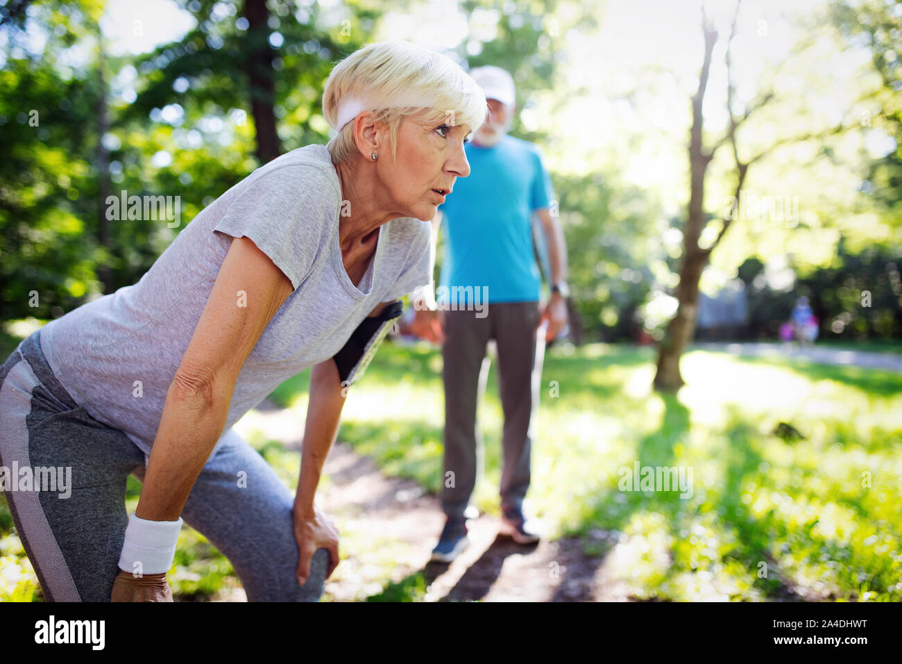Mature Woman stretching durant la marche dans le parc Banque D'Images
